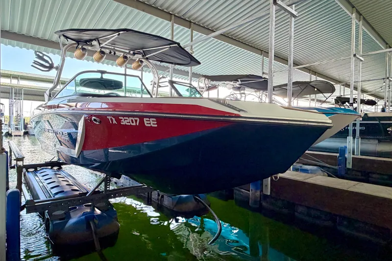 Slide: The Image of 2018 Nautique Super Air Nautique GS24 boat docked in a covered marina. - 14