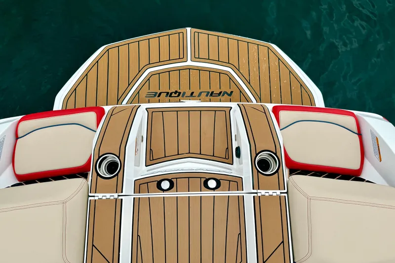 Slide: The Image of 2018 Nautique Super Air Nautique GS24 boat deck with teak finish and cushioned seating. - 16