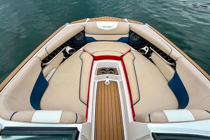 Slide: The Image of 2018 Nautique Super Air Nautique GS24 boat interior with beige, blue, and red seating. - 31
