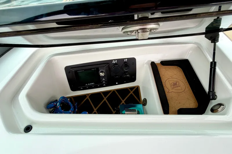 Slide: The Image of 2018 Nautique Super Air Nautique GS24 storage compartment with JL Audio system and accessories. - 36