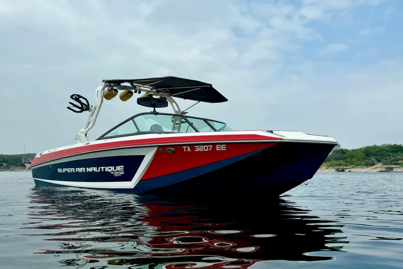 Slide: The Image of 2018 Nautique Super Air Nautique GS24 boat on calm water under a cloudy sky. - 4