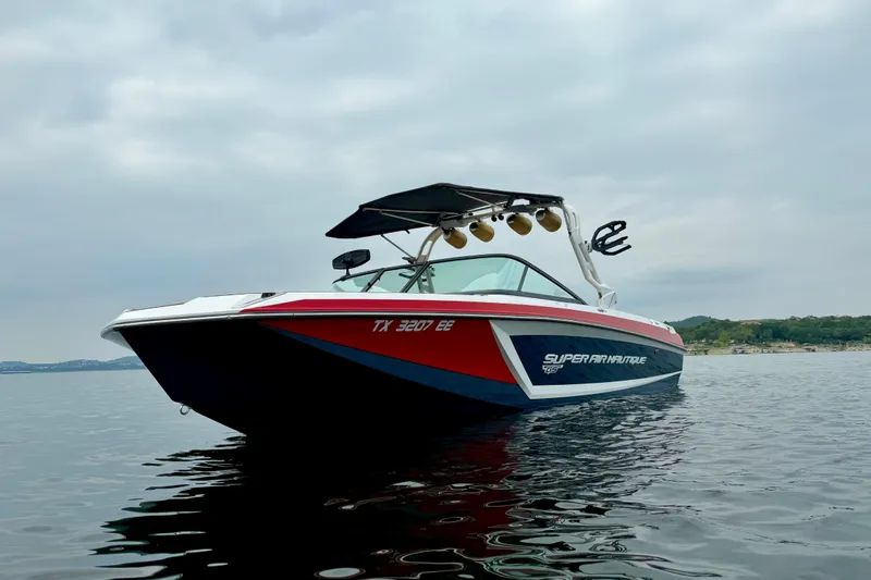 Slide: The Image of 2018 Nautique Super Air Nautique GS24 boat on calm water, overcast sky. - 5