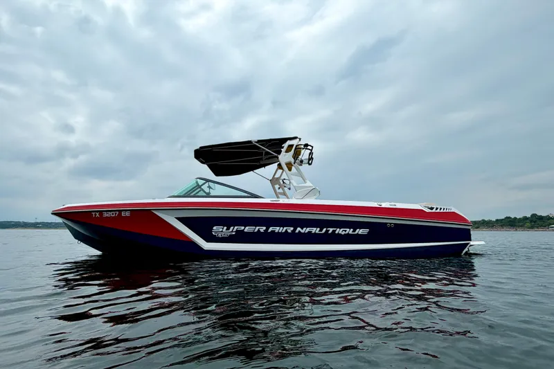 Slide: The Image of 2018 Nautique Super Air Nautique GS24 boat on calm water under cloudy sky. - 6