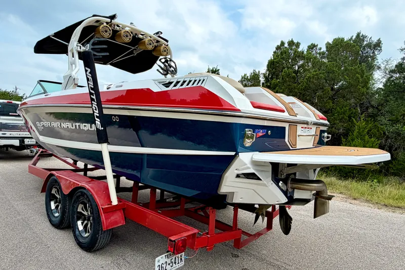 Slide: The Image of 2018 Nautique Super Air Nautique GS24 boat on red trailer, parked outdoors. - 9