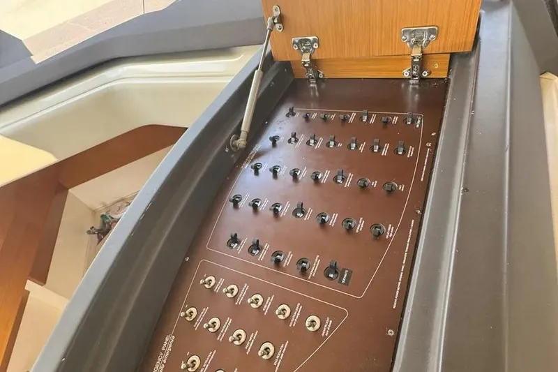 Slide: The Image of Control panel of a 2014 Azimut 45 yacht with multiple switches and wooden cover. - 20