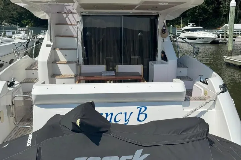 Slide: The Image of 2014 Azimut 45 yacht stern view with seating area and docked jet ski. - 23