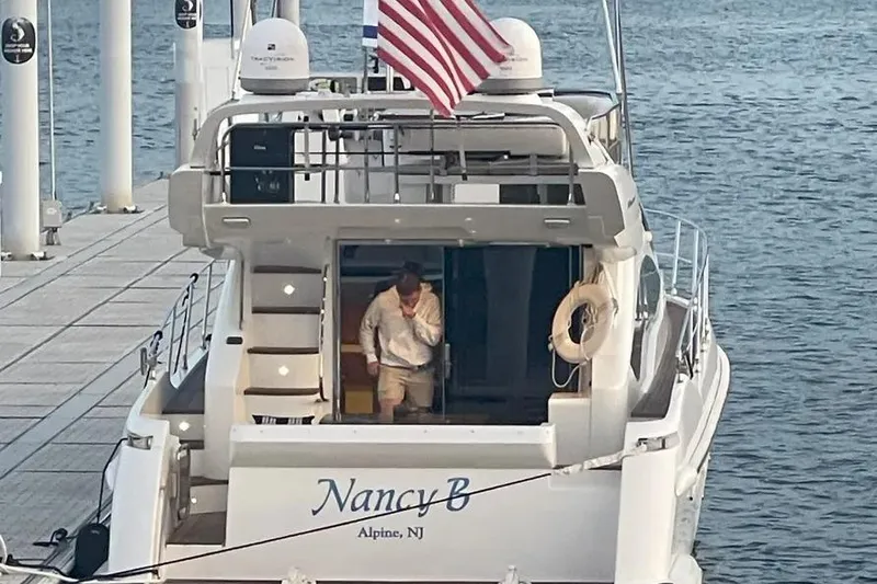 Slide: The Image of Azimut 45 yacht "Nancy B" docked, featuring American flag and person onboard. - 37