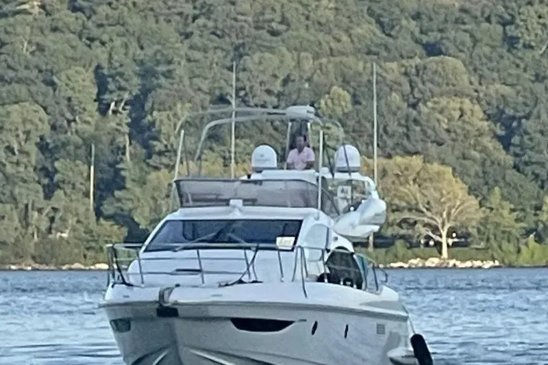 Slide: The Image of 2014 Azimut 45 yacht cruising on a serene lake with lush forest backdrop. - 54