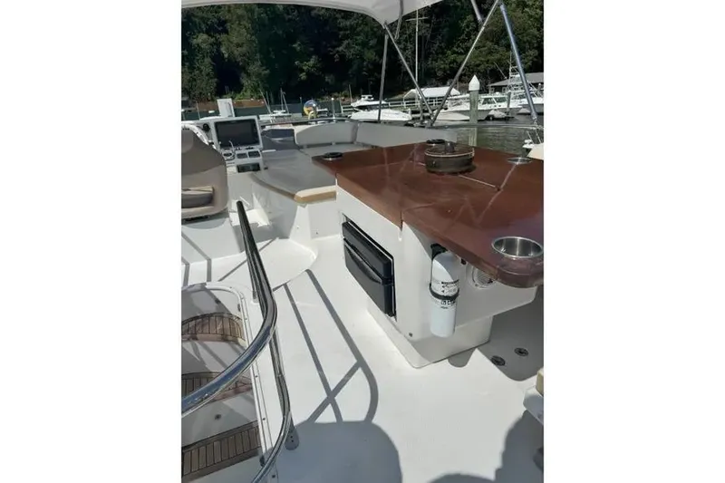 Slide: The Image of 2014 Azimut 45 yacht deck with seating and wooden table, docked at marina. - 67