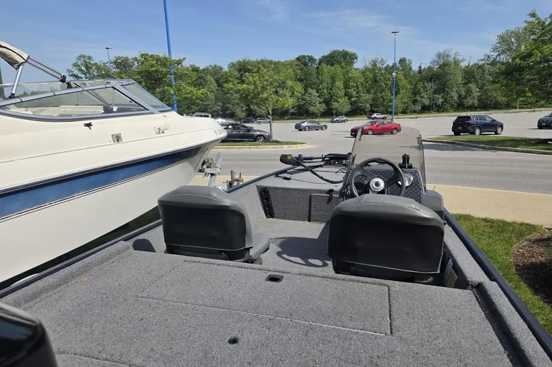 Slide: The Image of 2024 TRACKER MARINE CLASSIC XL boat interior with steering wheel and seats in a parking lot. - 7