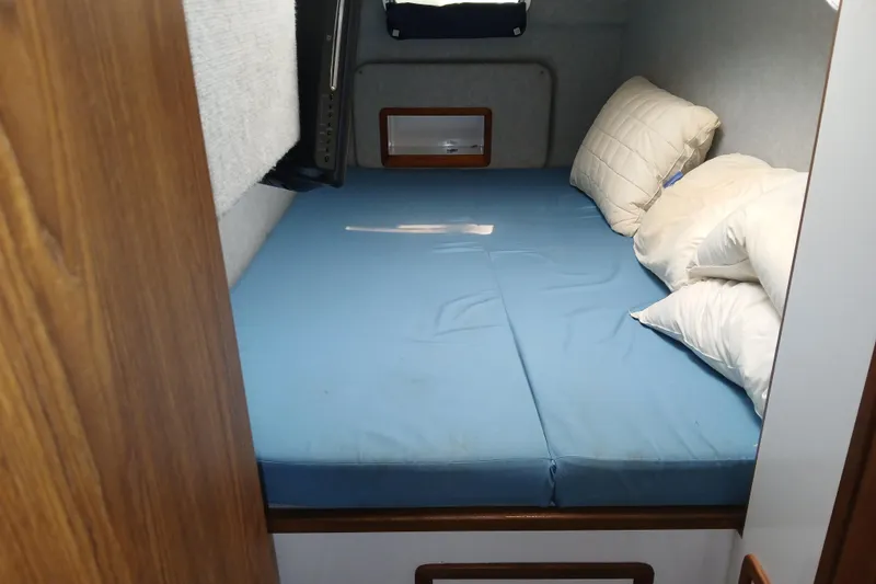 Slide: The Image of Cozy cabin bed in 1999 Endeavour Trawlercat 36 with blue bedding and pillows. - 22