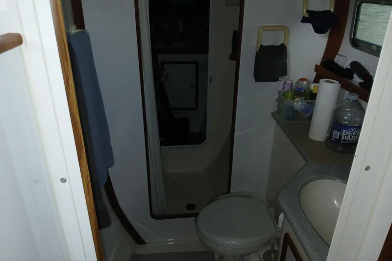 Slide: The Image of Bathroom interior of 1999 Endeavour Trawlercat 36, featuring sink, toilet, and shower area. - 23