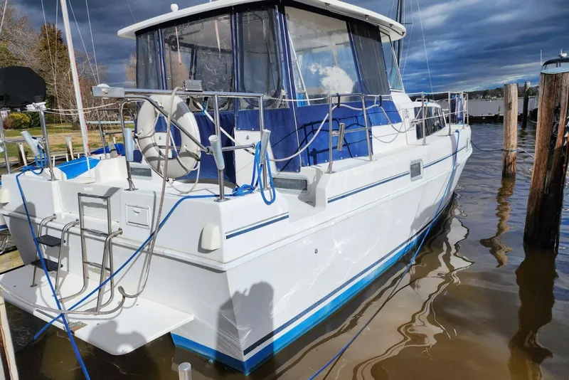 Slide: The Image of 1999 Endeavour Trawlercat 36 docked, featuring blue accents and safety equipment. - 3