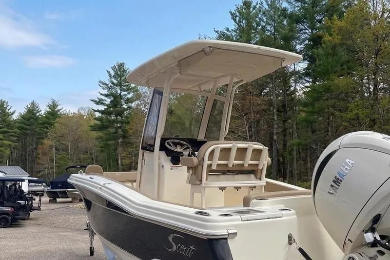 Slide: The Image of Scout 215 XSF 2025 boat with Yamaha engine parked outdoors. - 2