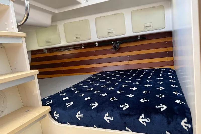 Slide: The Image of Cozy cabin interior of 2011 Reliance 44 with anchor-patterned bedding. - 15