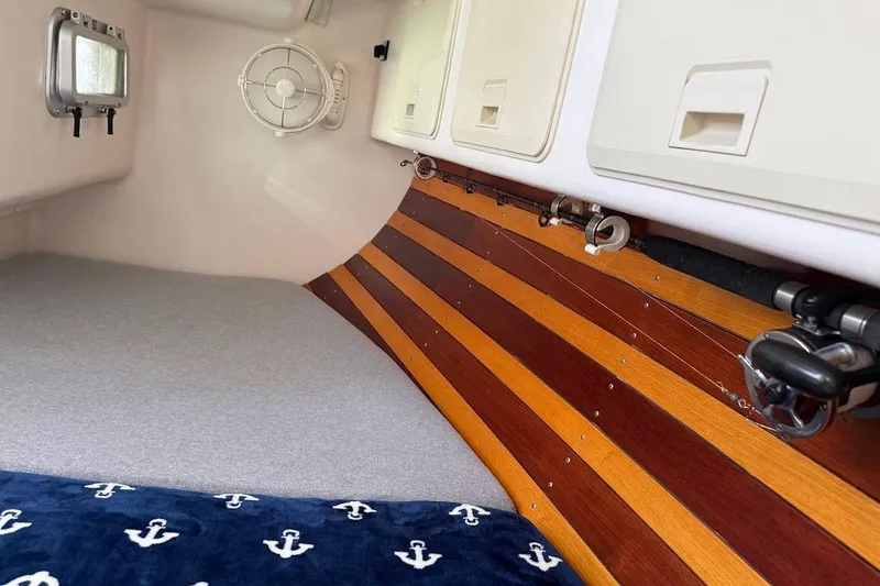 Slide: The Image of Cozy interior of 2011 Reliance 44 boat with wooden paneling and anchor-patterned blanket. - 16