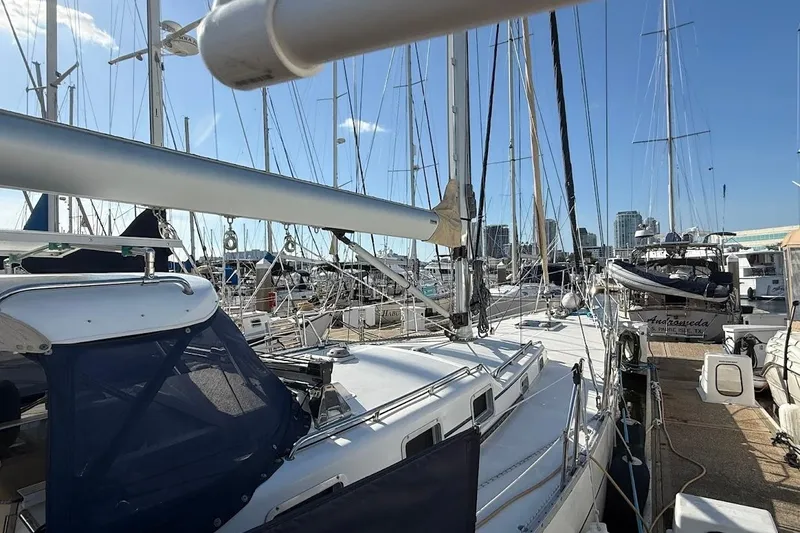 Slide: The Image of Sailboats docked at a marina, featuring a 2011 Reliance 44 model under clear blue skies. - 32
