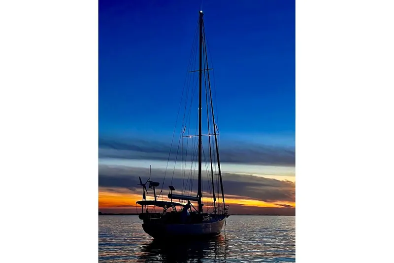 Slide: The Image of Sailboat silhouette at sunset, Reliance 44, 2011 model, on calm water. - 36