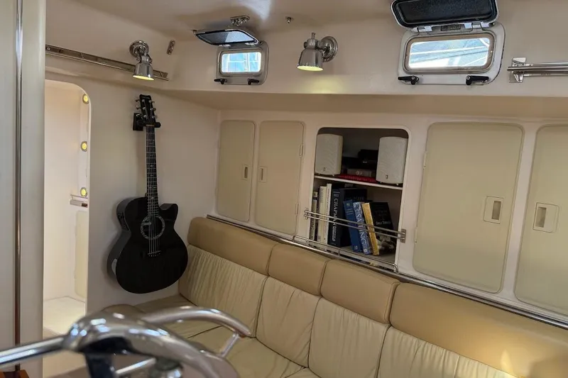 Slide: The Image of Cozy yacht interior with guitar, books, and beige seating on a 2011 Reliance 44. - 6