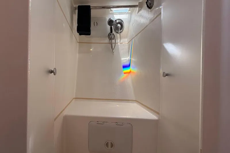 Slide: The Image of Compact shower area in a 2011 Reliance 44 boat, featuring a rainbow reflection. - 9