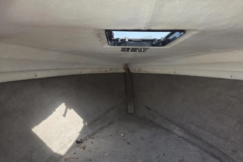 Slide: The Image of Interior cabin of a 1995 Sunbird Corsair boat, showing a hatch and carpeted surfaces. - 5