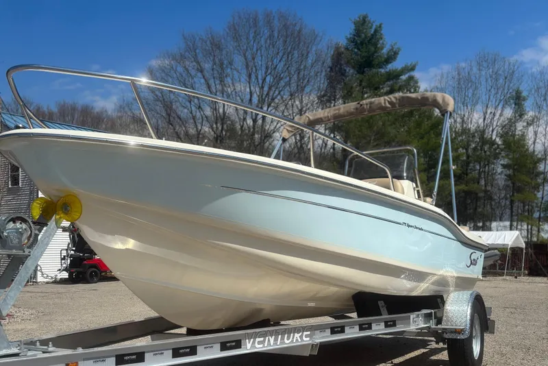 Slide: The Image of 2025 Scout 175 Sport Dorado boat on trailer outdoors. - 2