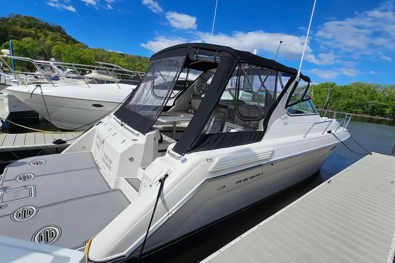 Slide: The Image of 1997 Regal Commodore 402 boat docked, featuring sleek design and black canopy. - 2