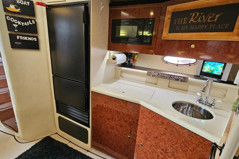 Slide: The Image of Cozy kitchen area in a 1997 Regal Commodore 402 boat with wood accents and modern amenities. - 22