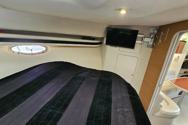 Slide: The Image of Interior of 1997 Regal Commodore 402 yacht with bed, TV, and porthole window. - 25