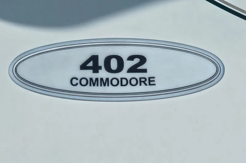 Slide: The Image of Regal Commodore 402 emblem, 1997 model, oval design with black text on white background. - 40