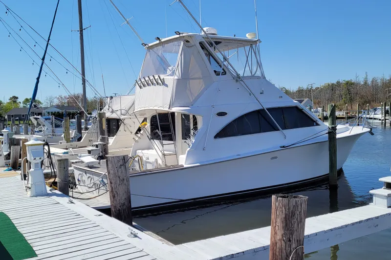 The Image of 1993 Ocean Yachts 38 Super Sport docked at a marina under clear blue skies. - 1