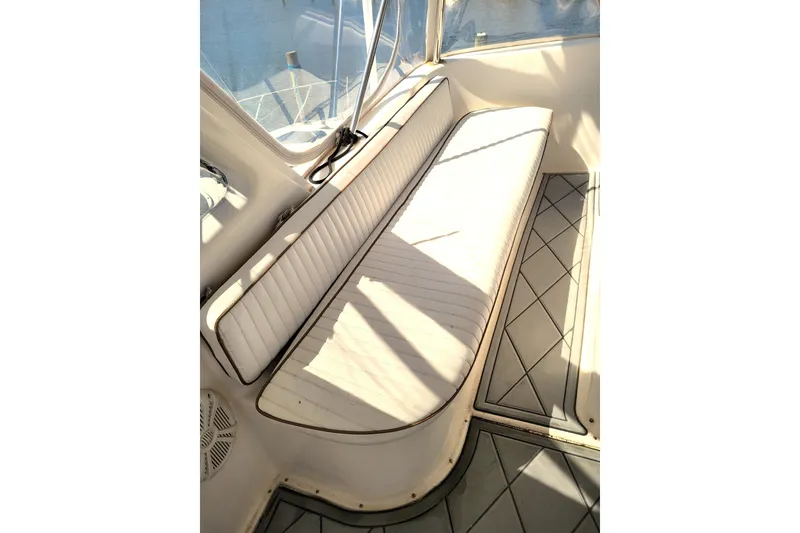 Slide: The Image of 1993 Ocean Yachts 38 Super Sport interior with white cushioned seating and scenic marina view. - 11