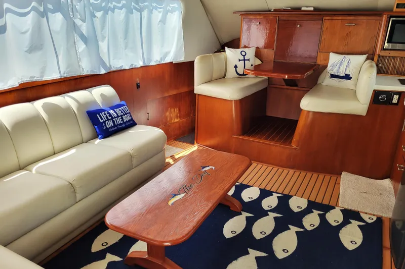 Slide: The Image of Interior seating of 1993 Ocean Yachts 38 Super Sport, featuring cushioned bench and patterned flooring. - 12