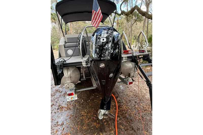 Slide: The Image of 2023 Barletta Corsa 23U pontoon boat with outboard motor and American flag. - 9