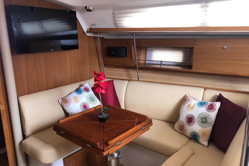 Slide: The Image of Interior of 2020 Catalina 355 yacht with cozy seating, wooden table, and decorative pillows. - 3