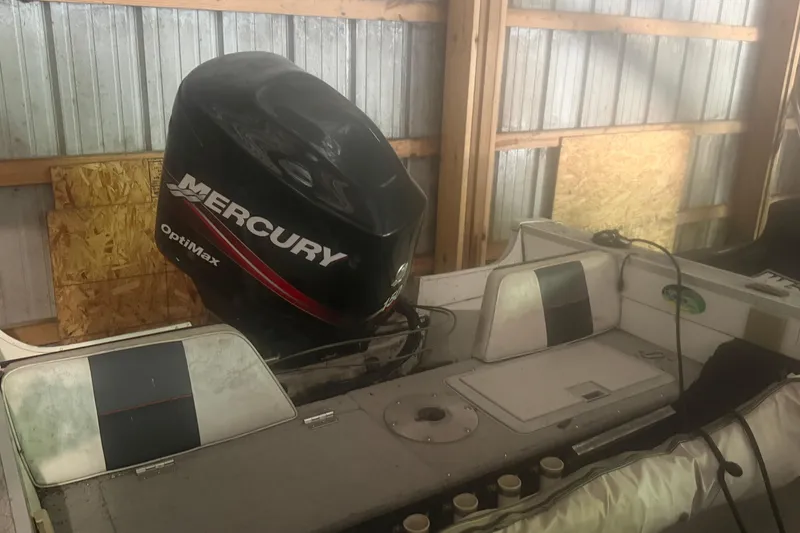 Slide: The Image of 1994 Smoker Craft 182 Pro Mag boat with Mercury OptiMax engine in storage. - 2