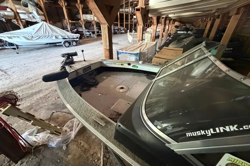 Slide: The Image of 1994 Smoker Craft 182 Pro Mag boat stored indoors, featuring a covered motor and windshield. - 5