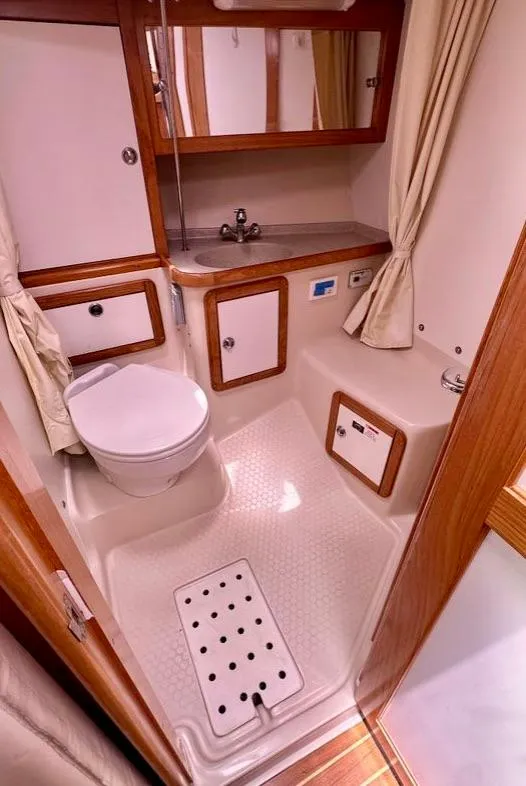 Slide: The Image of 2007 Catalina 36 MkII yacht bathroom with toilet, sink, and wooden cabinetry. - 15