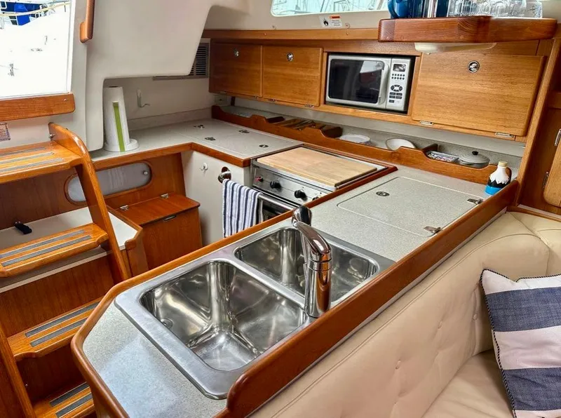 Slide: The Image of Interior of 2007 Catalina 36 MkII sailboat, featuring a modern kitchen with wood cabinetry. - 9