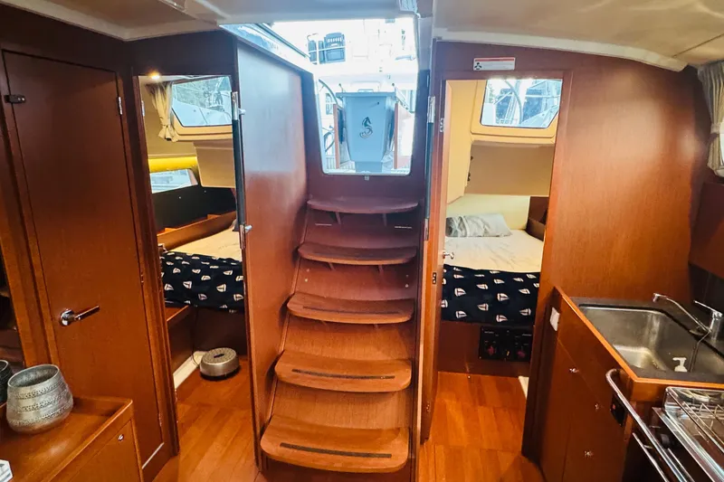 Slide: The Image of Interior of 2018 Beneteau Oceanis 41.1 yacht, featuring cozy cabins and wooden finishes. - 12