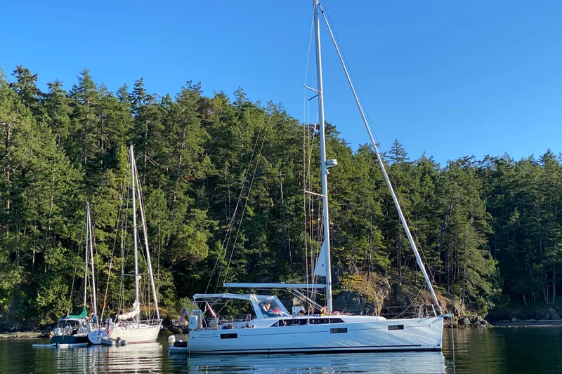 Slide: The Image of 2018 Beneteau Oceanis 41.1 sailboat anchored near lush forested shoreline. - 4
