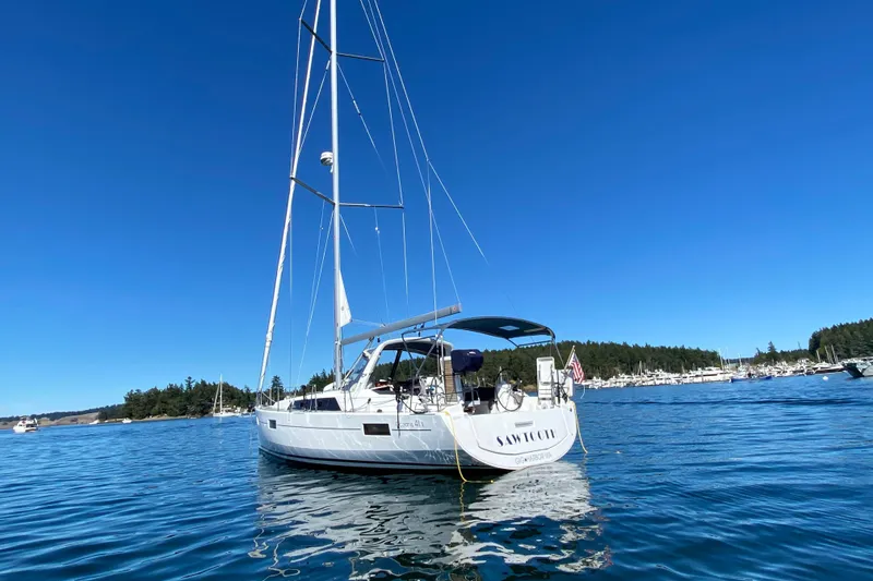 Slide: The Image of 2018 Beneteau Oceanis 41.1 sailboat anchored in a serene harbor under clear blue skies. - 5