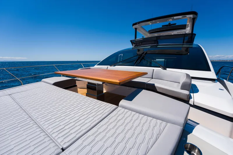 Slide: The Image of Luxurious 2024 Pearl 72 yacht deck with seating and table, under clear blue sky. - 100