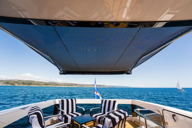 Slide: The Image of Luxury yacht Pearl 72 deck with striped chairs, ocean view, 2024 model. - 113