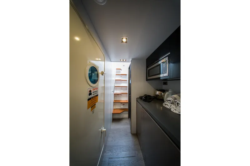 Slide: The Image of Modern yacht interior with kitchenette, microwave, and stairs; Pearl 72, 2024 model. - 126