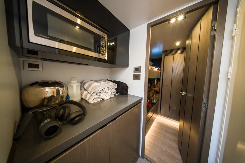 Slide: The Image of Modern kitchen area in 2024 Pearl 72 yacht with microwave, towels, and sleek cabinetry. - 127