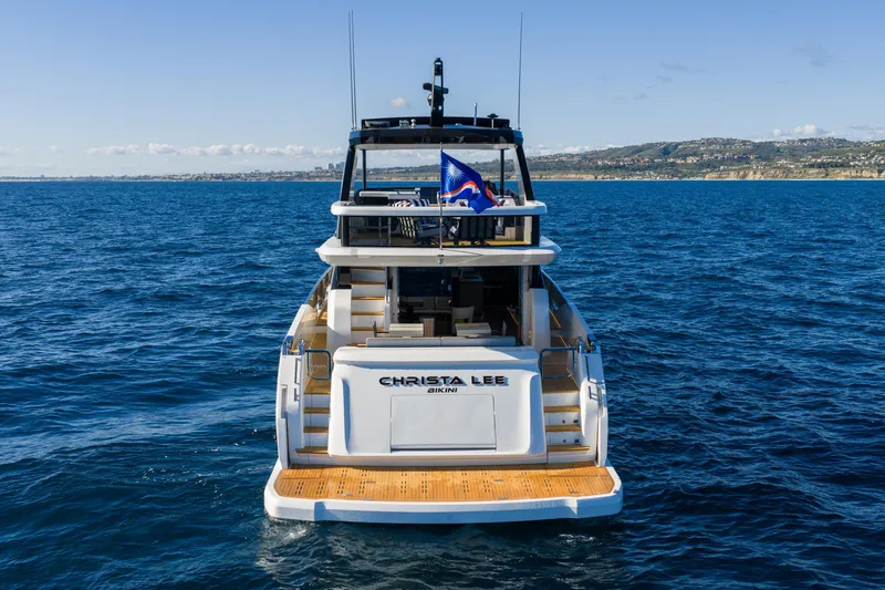 Slide: The Image of 2024 Pearl 72 yacht on open sea, rear view with coastline in background. - 27