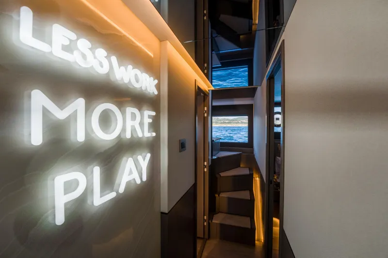 Slide: The Image of Modern yacht interior with illuminated "Less Work More Play" sign, Pearl 72, 2024 model. - 67