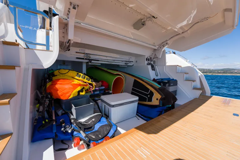 Slide: The Image of Storage compartment on a 2024 Pearl 72 yacht, filled with water sports equipment. - 81