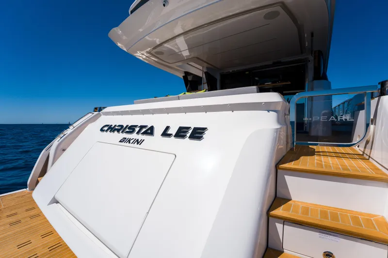 Slide: The Image of Luxury Pearl 72 yacht, 2024 model, docked with wooden steps and ocean backdrop. - 86